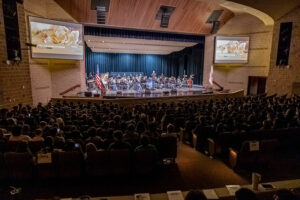 US Army Field Band on stage in a crowded auditorium
